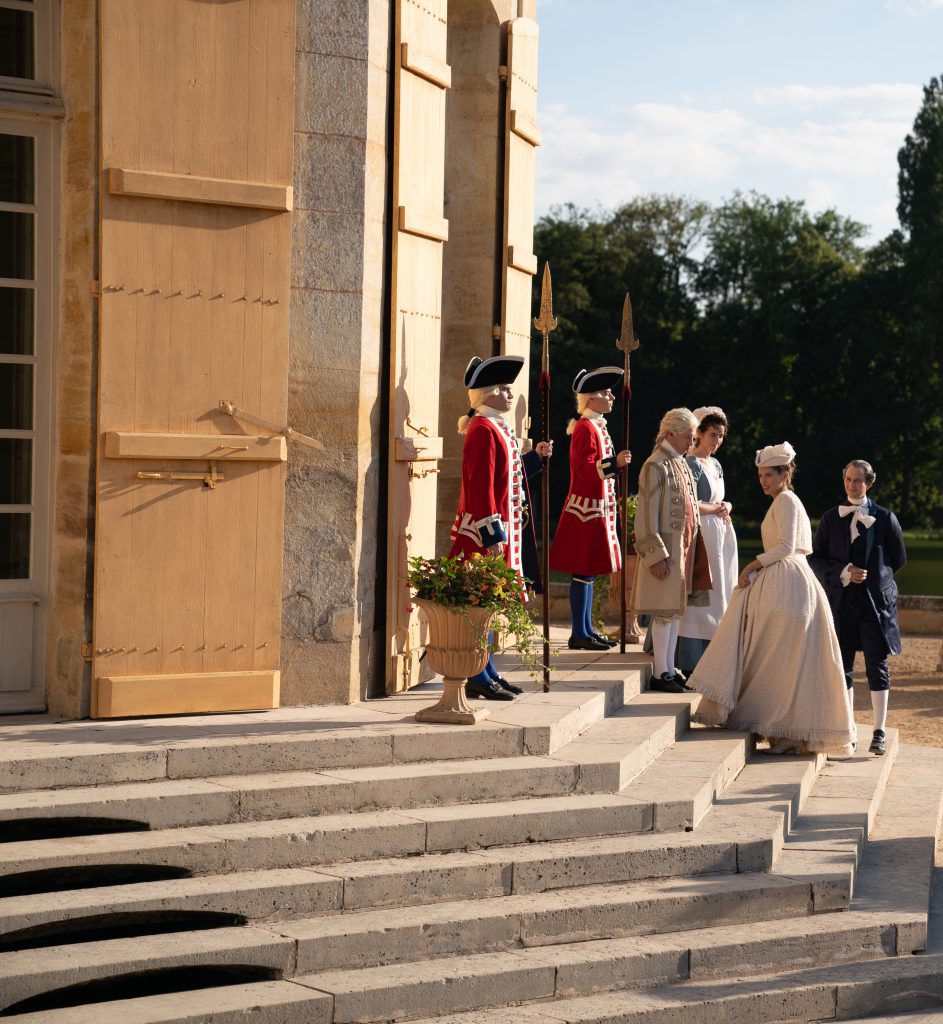 Nhóm người mặc trang phục lịch sử đứng trước một tòa nhà cổ kính