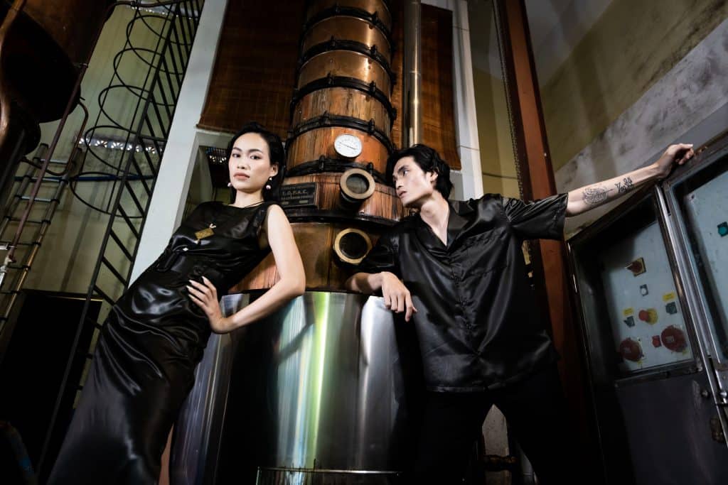 Một cặp đôi thời trang tạo dáng bên thiết bị công nghiệp kim loại lớn