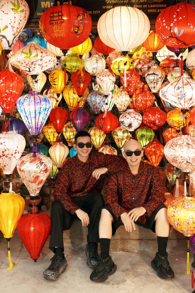 Hai nghệ sĩ VUNGOC&SON ngồi trước những chiếc đèn lồng rực rỡ tại phố cổ Hội An