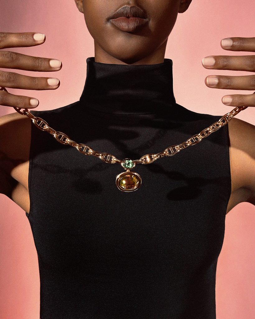 Người mẫu đeo dây chuyền vàng hồng Hermès Chaine D'Ancre trên nền hồng nhạt