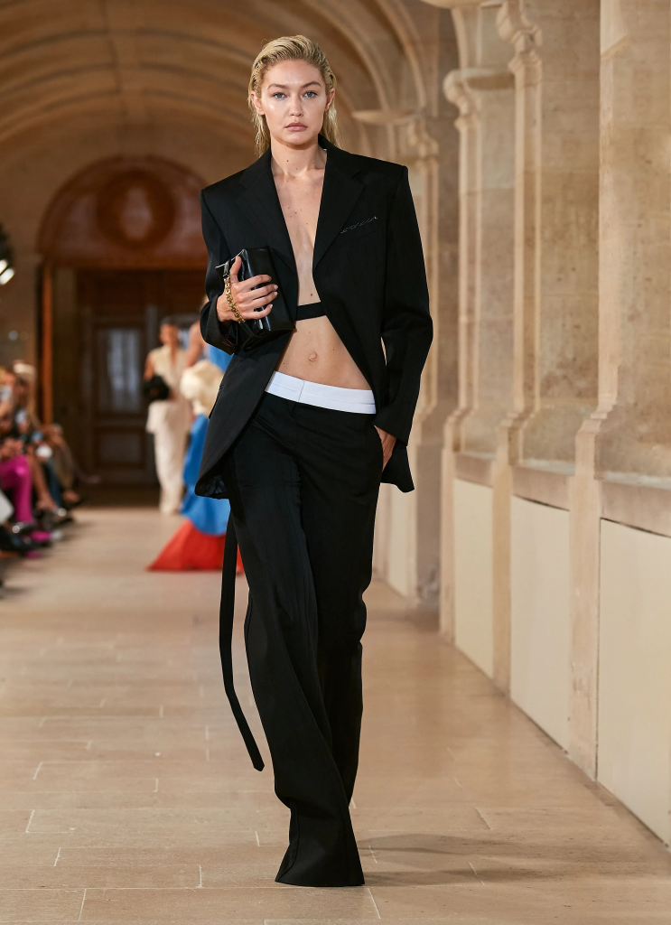 Người mẫu trình diễn bộ suit đen thanh lịch với áo ngực trắng bên trong