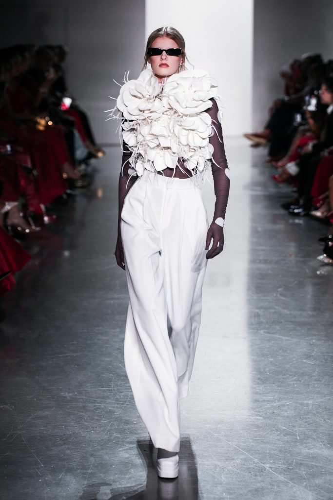 Người mẫu trình diễn trang phục trắng tinh tế với điểm nhấn hoa điệu đà trên sàn catwalk