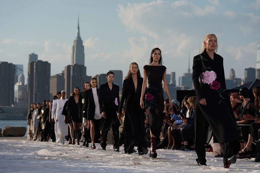 Models walk a runway overlooking the New York City skyline during a fashion show
