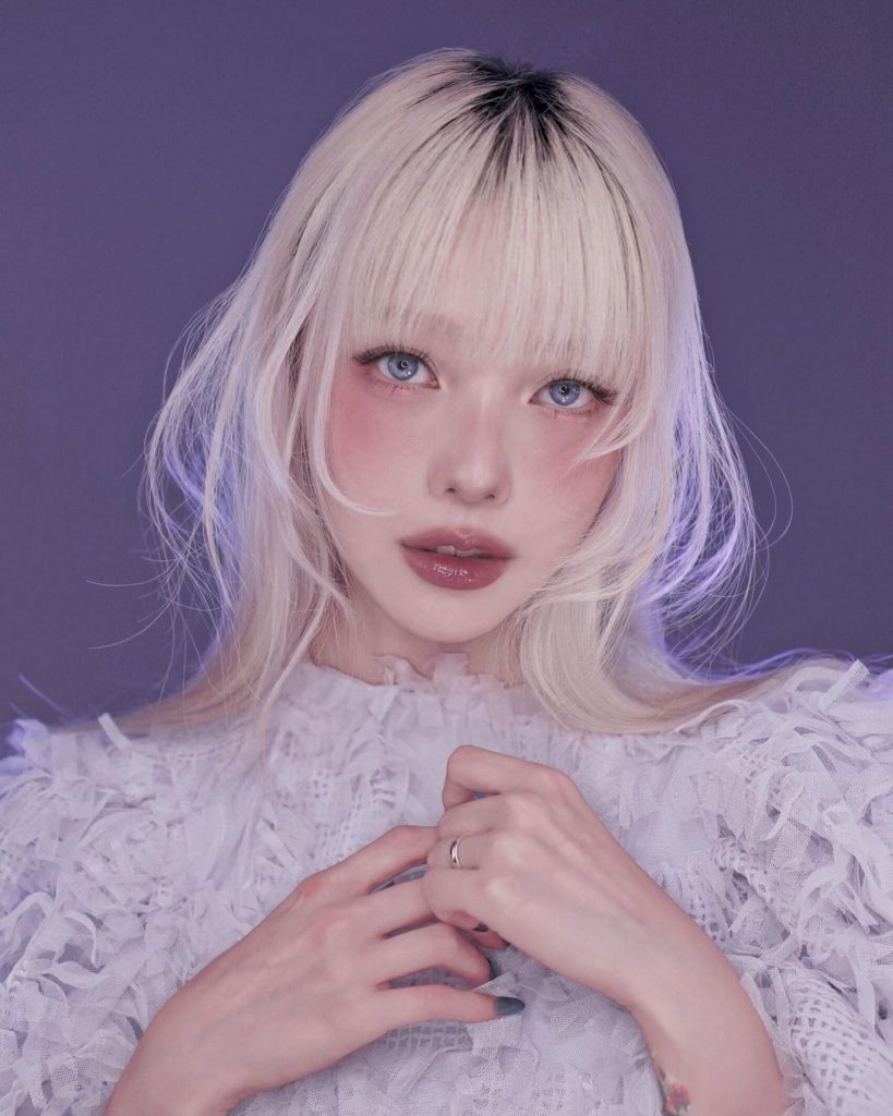 Cô gái trẻ với mái tóc bạch kim và đôi mắt khác màu nhìn thẳng vào ống kính