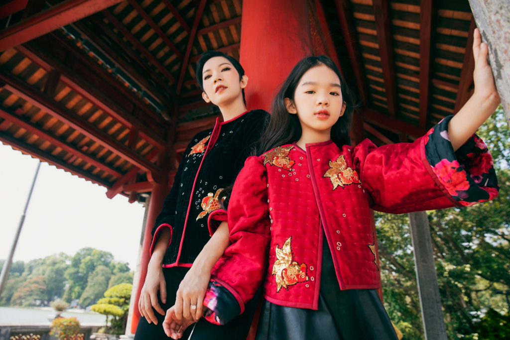 Hai thiếu nữ mặc áo chần bông truyền thống bên kiến trúc cổ kính Hà Nội