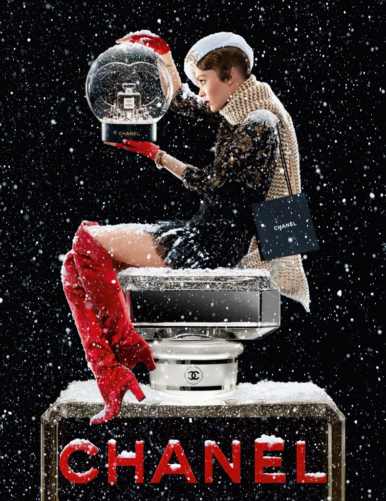 Người mẫu Chanel thanh lịch bên quả cầu tuyết và hộp quà trong khung cảnh mùa đông
