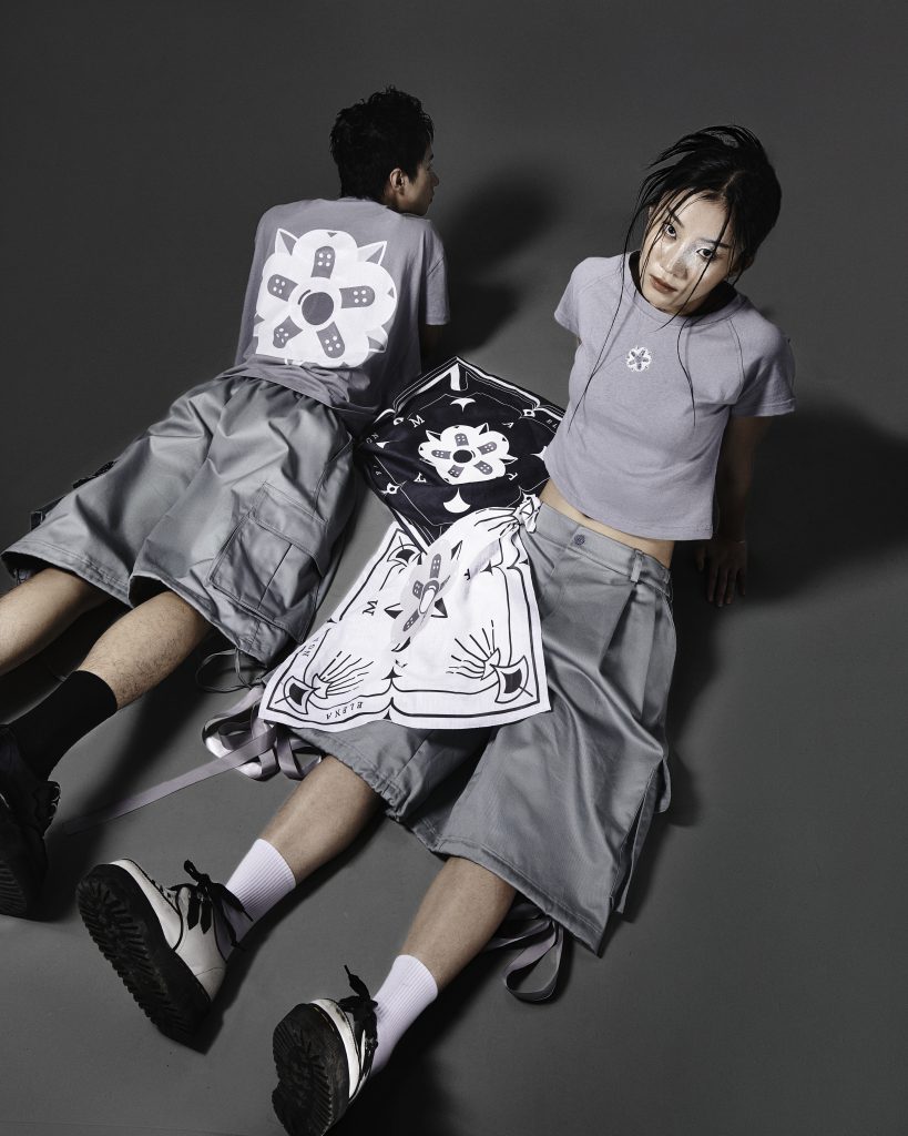 Hai người mẫu trình diễn trang phục đường phố kiểu dáng hiện đại trên nền xám