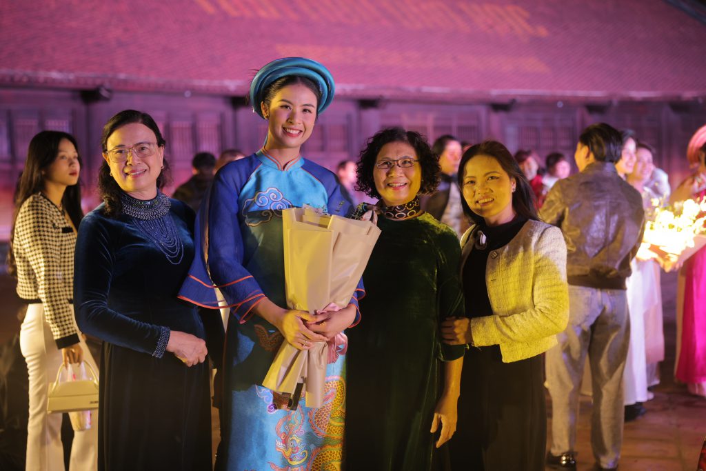 Năm người phụ nữ tươi cười rạng rỡ trong trang phục truyền thống và hiện đại tại một sự kiện