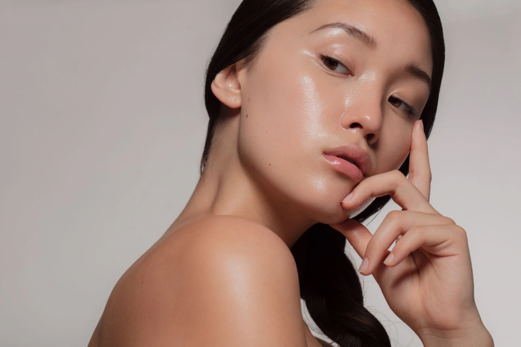 Cô gái trẻ với làn da sáng mịn đang khẽ chạm vào má