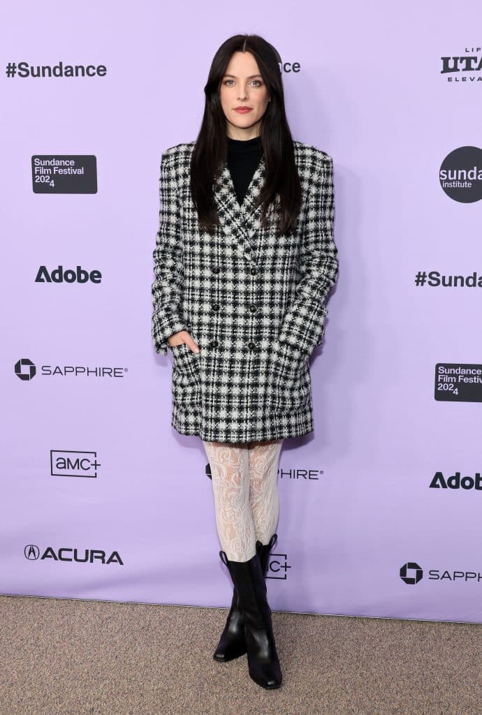 Một phụ nữ mặc áo khoác kẻ sọc và tất hoa trên thảm đỏ Liên hoan phim Sundance 2024