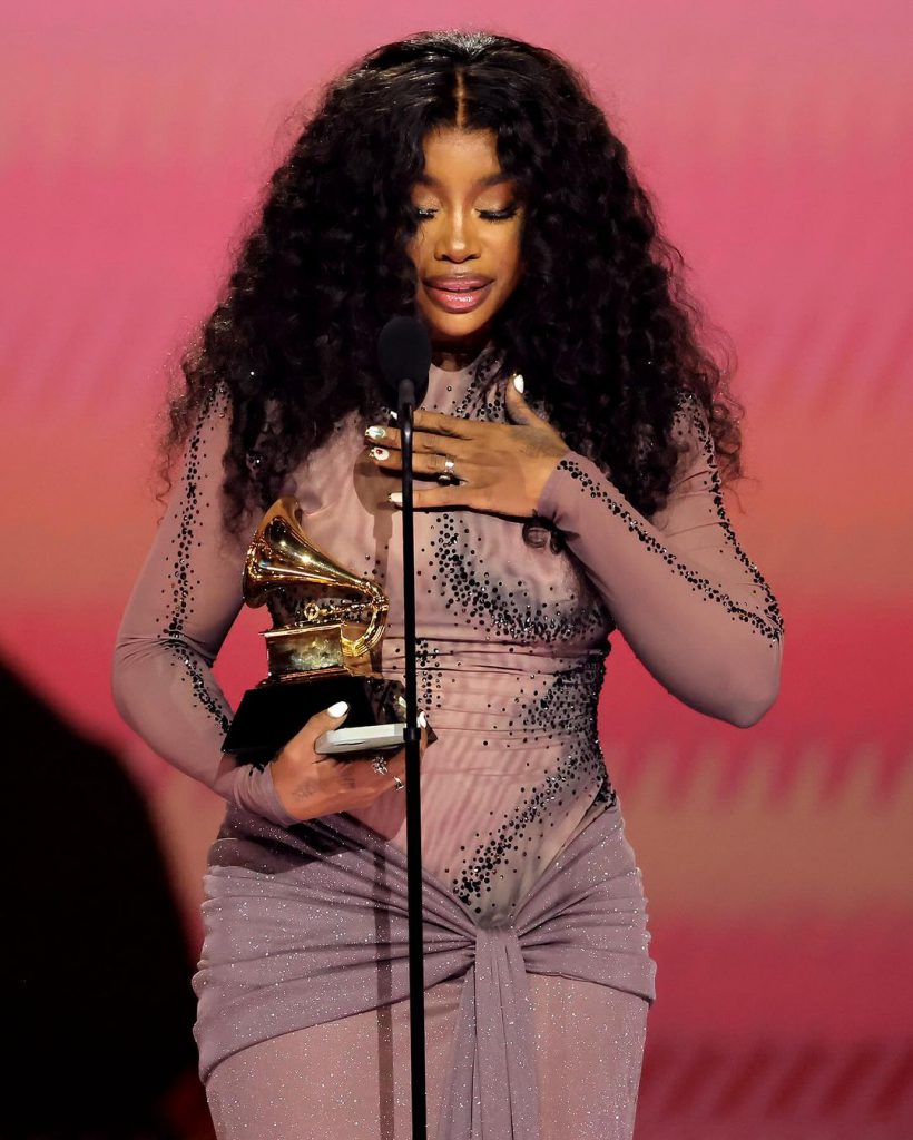 Nữ ca sĩ hạnh phúc ôm tượng Grammy trên sân khấu với đầm tím lấp lánh