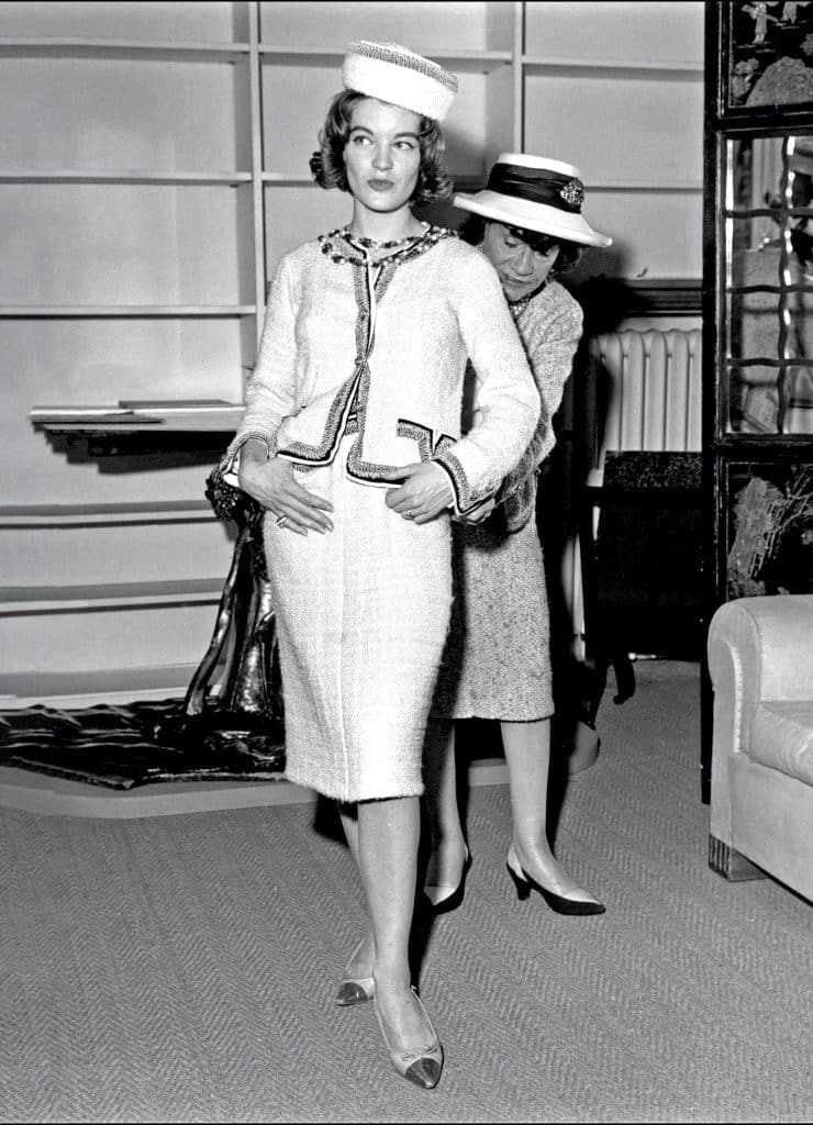 Người mẫu mặc trang phục Chanel cổ điển đang được chỉnh sửa bởi một người khác