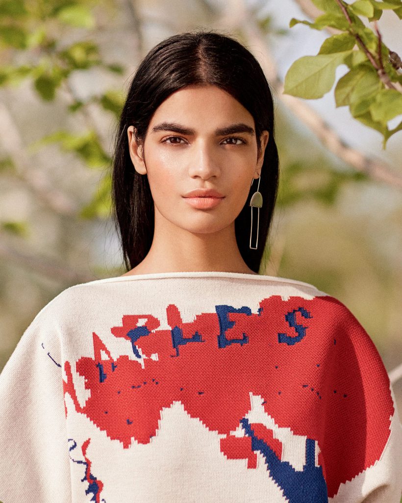 Người mẫu tóc đen mặc áo len họa tiết bản đồ với khuôn mặt trang điểm tự nhiên