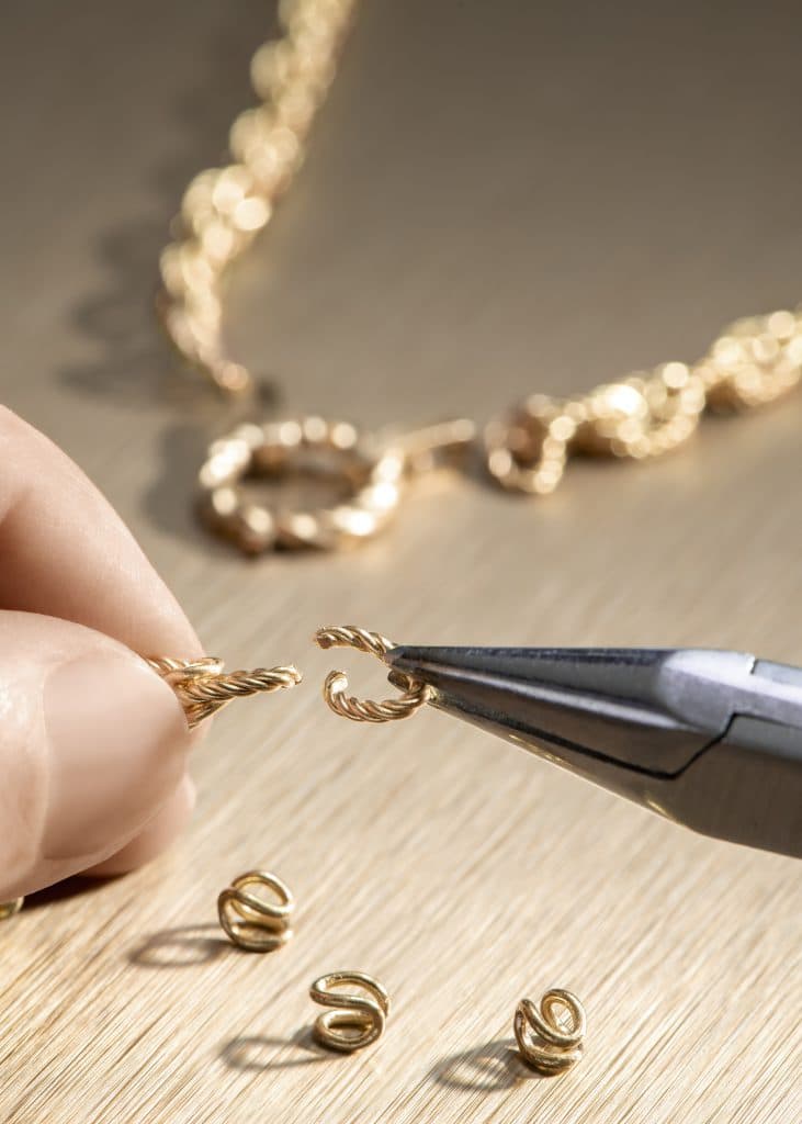 Thợ kim hoàn đang khéo léo lắp ráp các mắt xích vàng tạo nên một chiếc vòng cổ tinh xảo