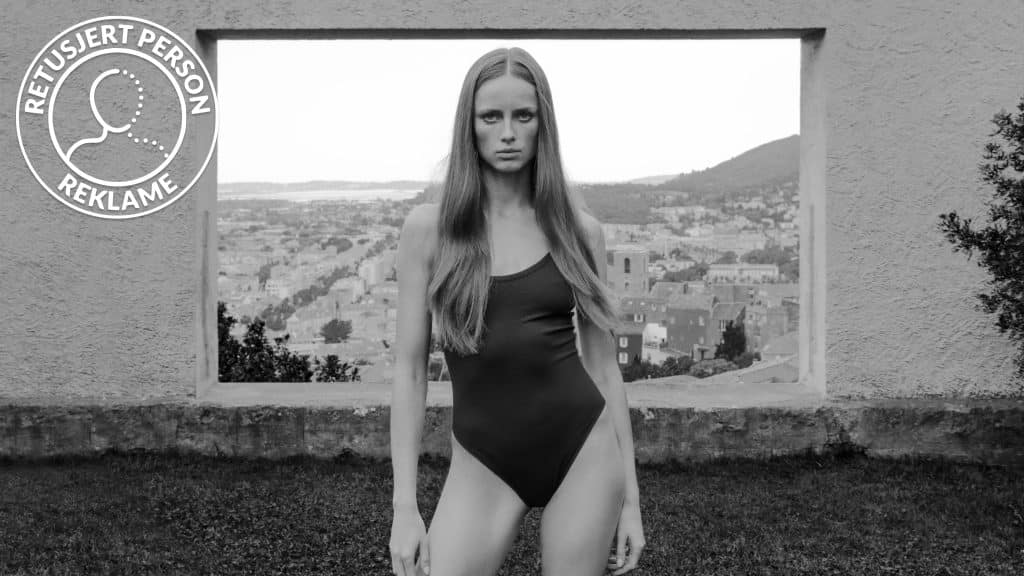 Người mẫu diện đồ bơi một mảnh đứng trước khung cửa sổ nhìn ra cảnh quan đồi núi