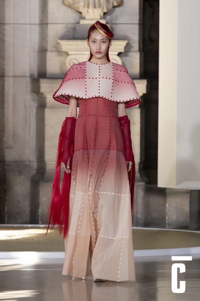 Người mẫu trình diễn trang phục dạ hội màu hồng và đỏ trong sảnh trang trí cổ điển