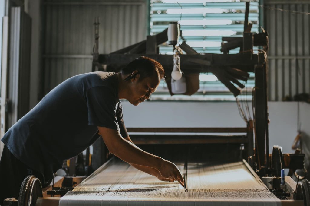 Người thợ đang tỉ mỉ thao tác trên khung dệt truyền thống