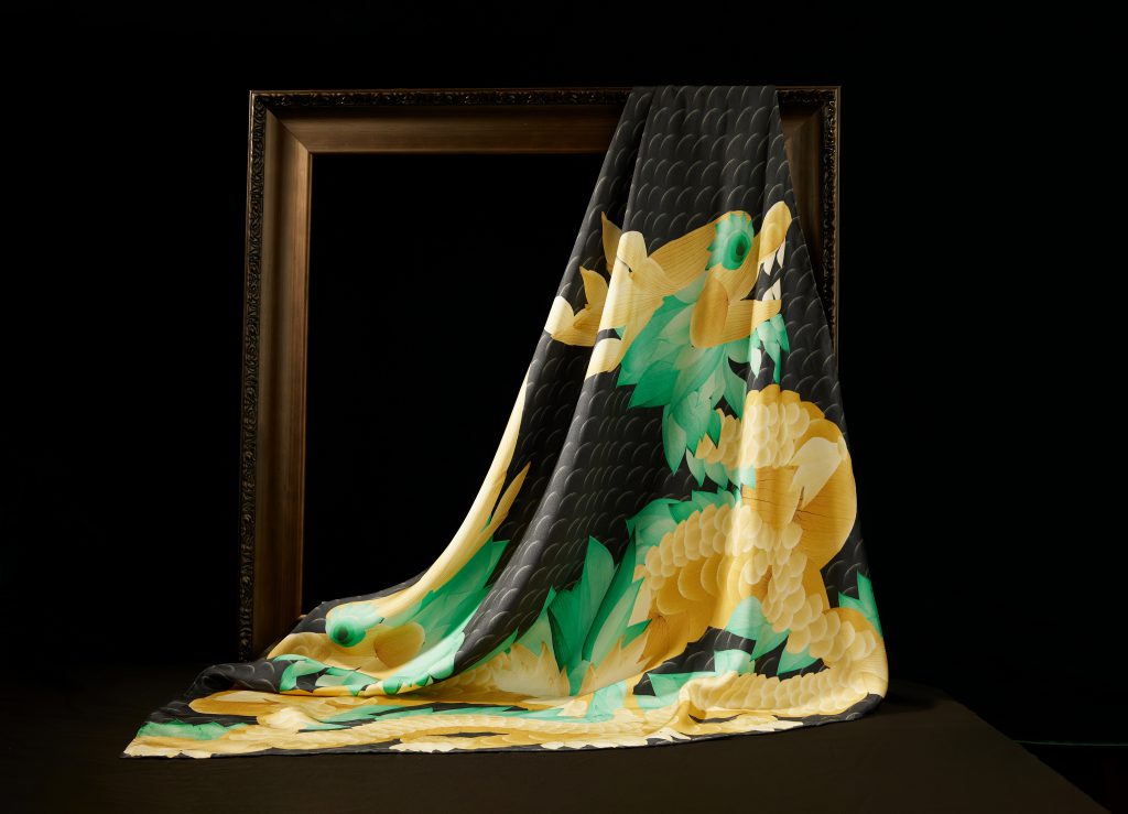 Khăn lụa DeSilk màu vàng xanh với họa tiết hoa lá mềm mại buông rủ qua khung tranh