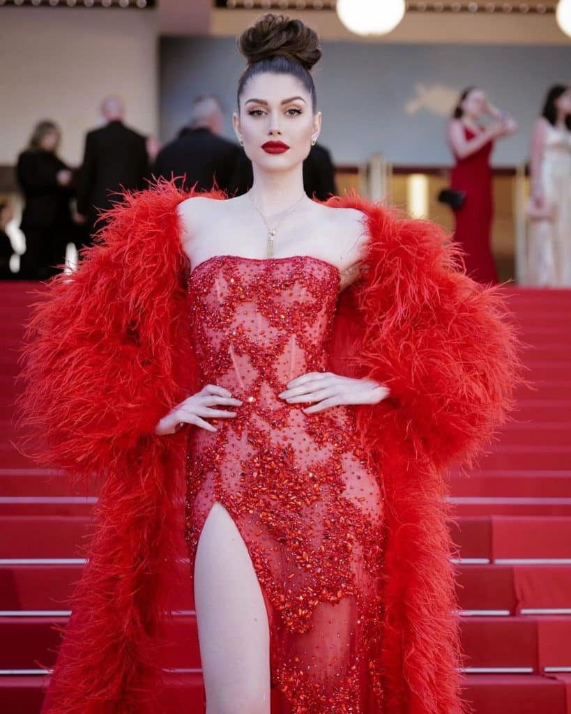 Người mẫu diện váy đỏ lộng lẫy cùng áo choàng lông vũ trên thảm đỏ Cannes