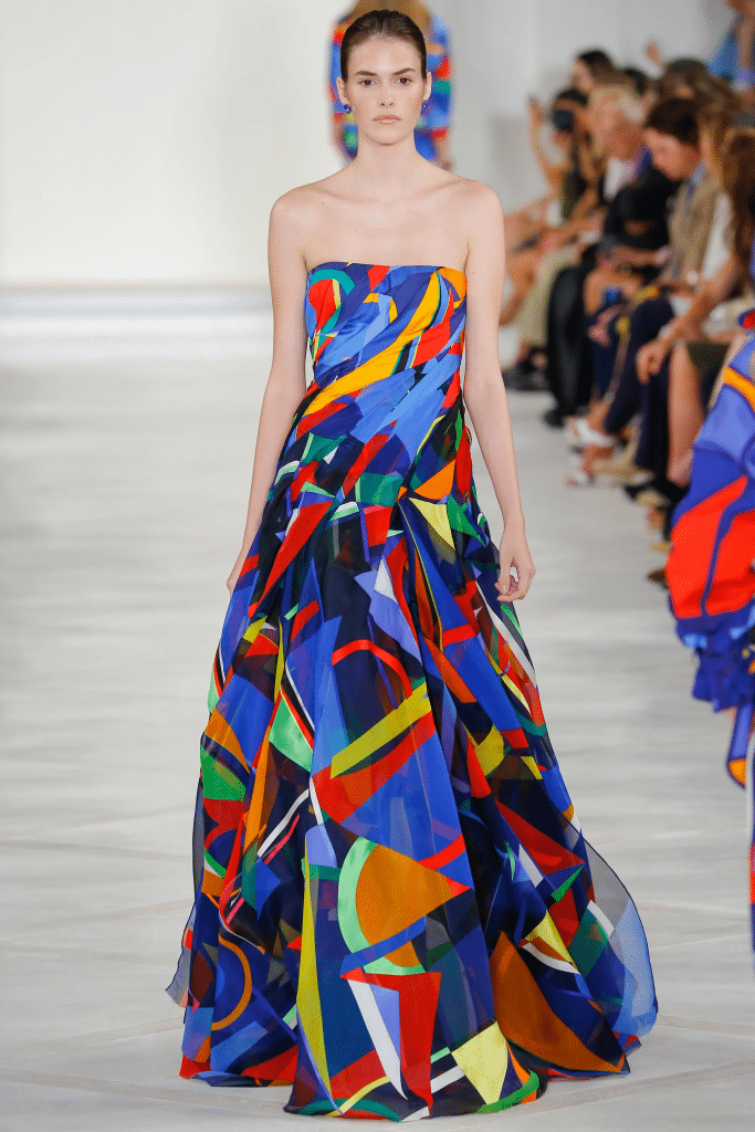 Người mẫu trình diễn váy dài họa tiết hình học màu sắc trên sàn catwalk