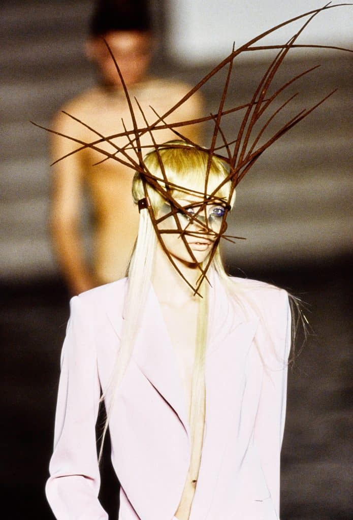 Người mẫu trình diễn trang phục với chiếc mũ làm từ các thanh kim loại nhọn