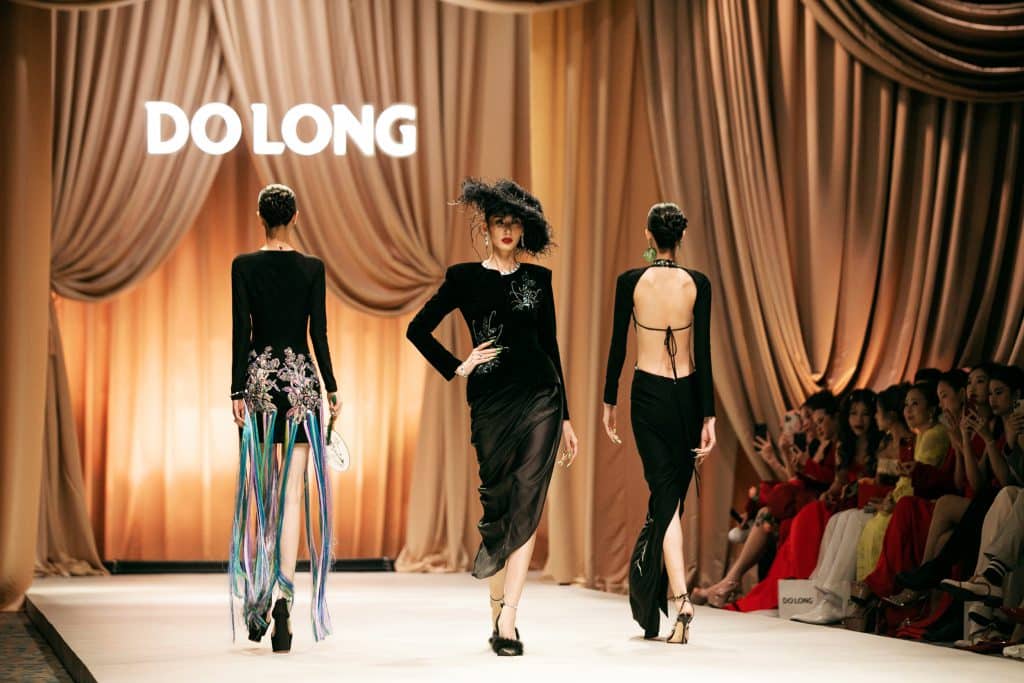 Ba người mẫu trình diễn trang phục trên sàn catwalk sang trọng
