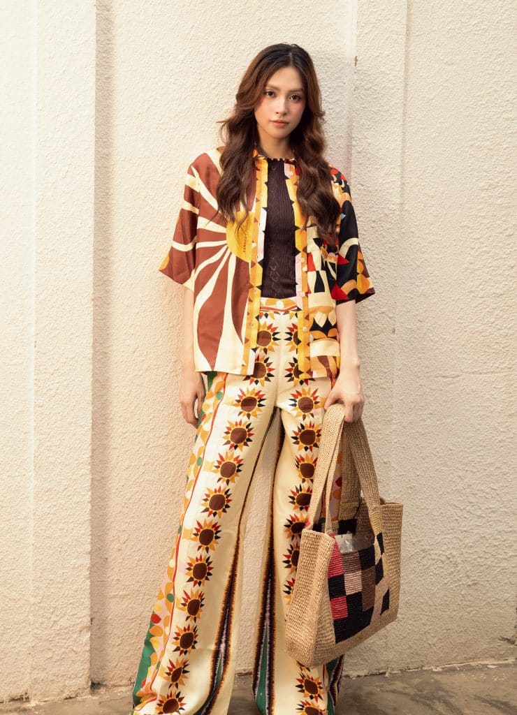 Tiểu Vy diện trang phục Sandro họa tiết hoa hướng dương tươi tắn cùng túi cói
