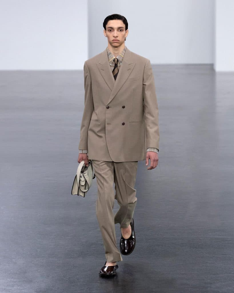 Người mẫu nam trình diễn bộ suit màu be với túi xách Fendi trên sàn diễn