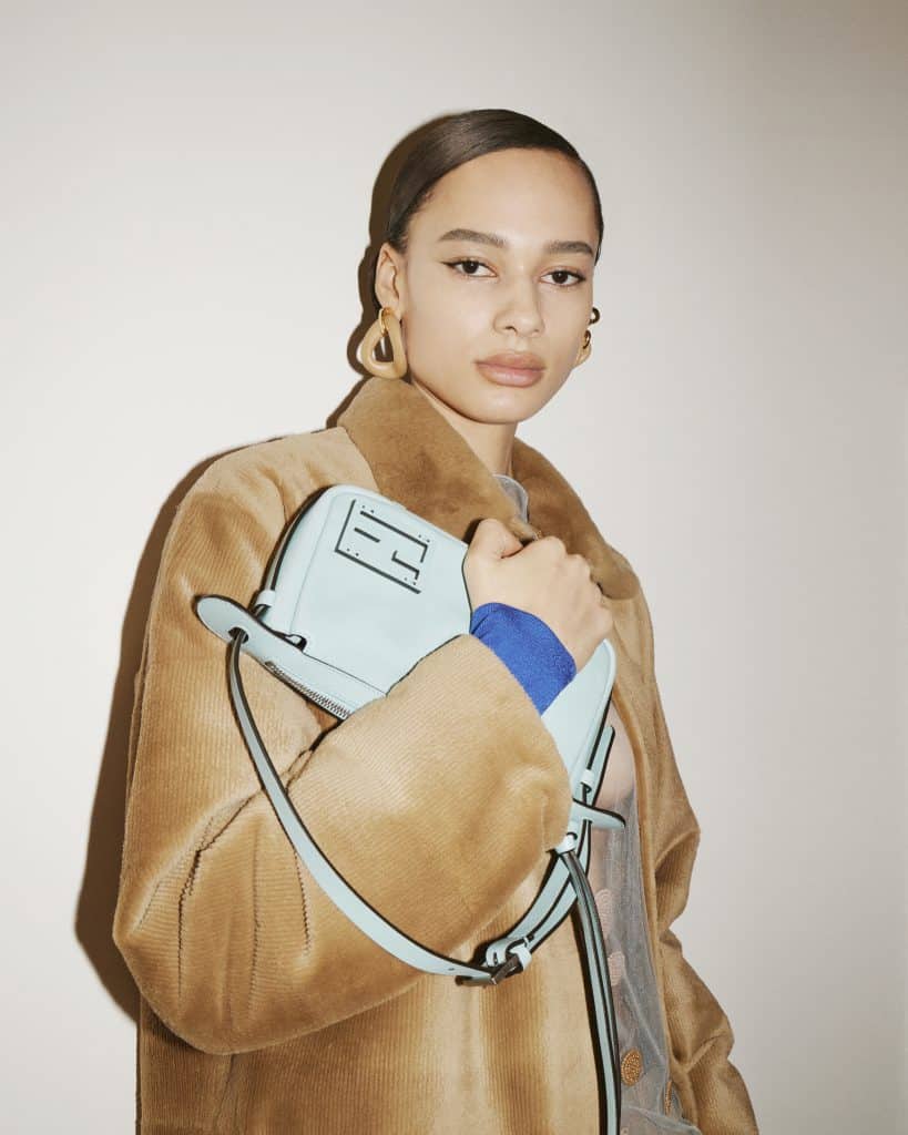 Người mẫu ôm túi xách FENDI màu xanh nhạt cùng áo khoác lông màu be