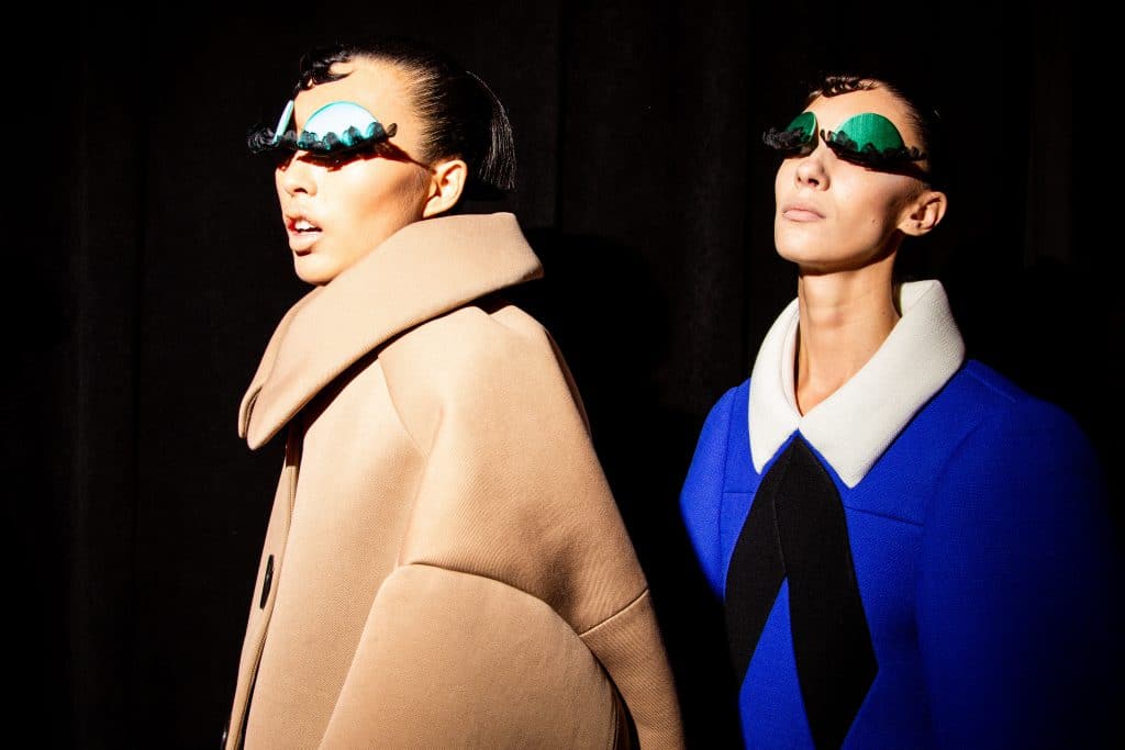 Hai người mẫu trình diễn trang phục độc đáo với kính mát hình mây xanh trong buổi giới thiệu bộ sưu tập Thu/Đông 2024