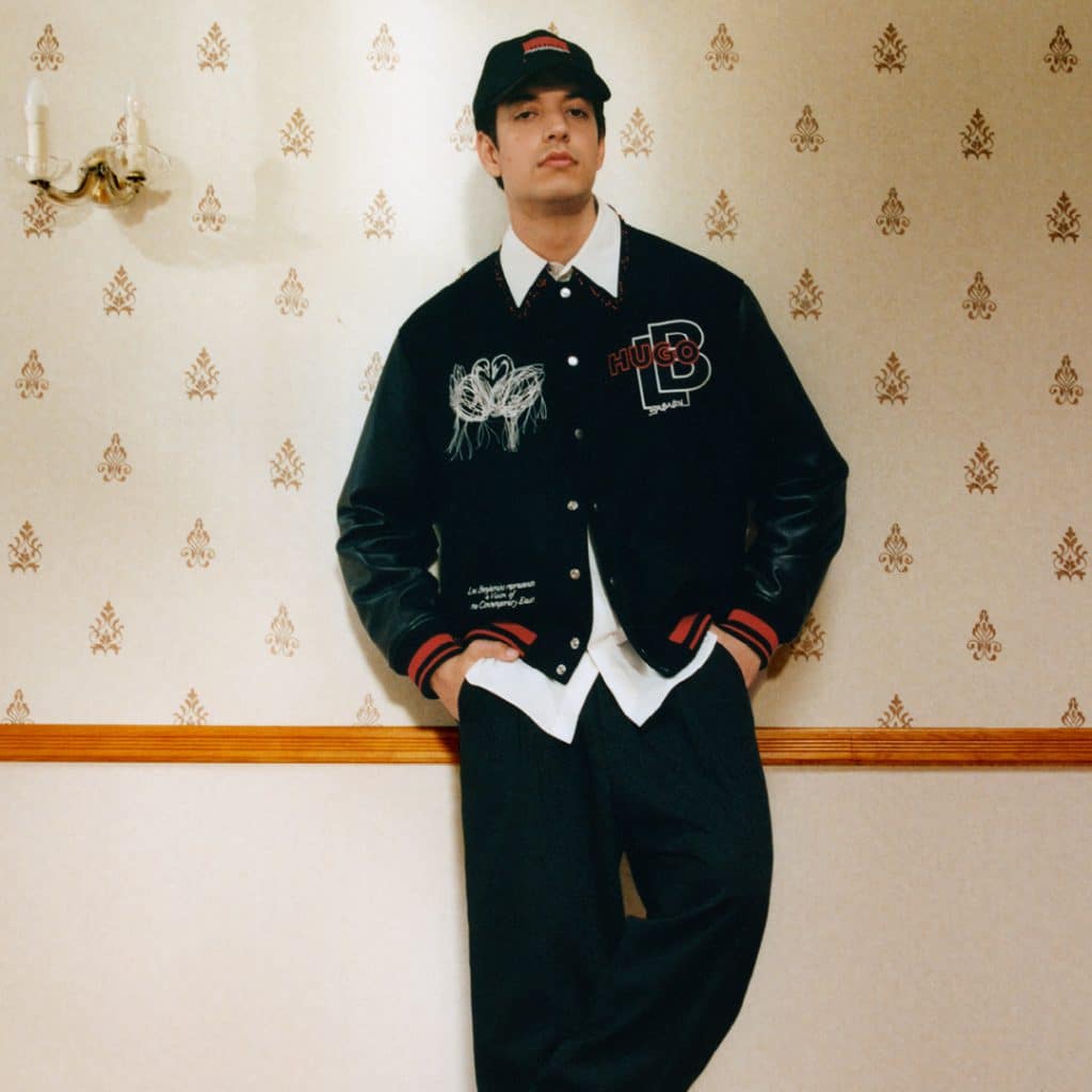 Người mẫu mặc áo khoác và quần thể thao trong phòng có tường hoa văn