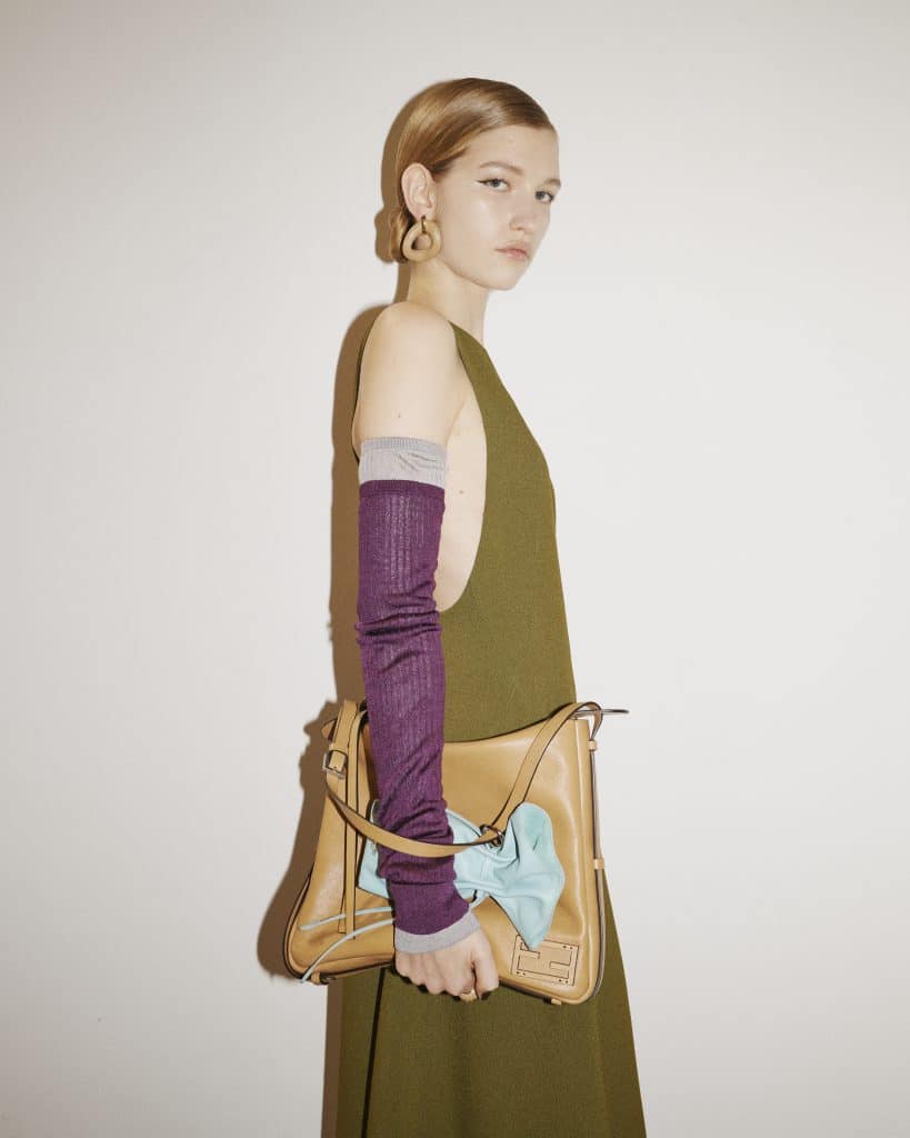 Người mẫu đeo túi xách FENDI màu nâu và tím cùng váy xanh lục bảo