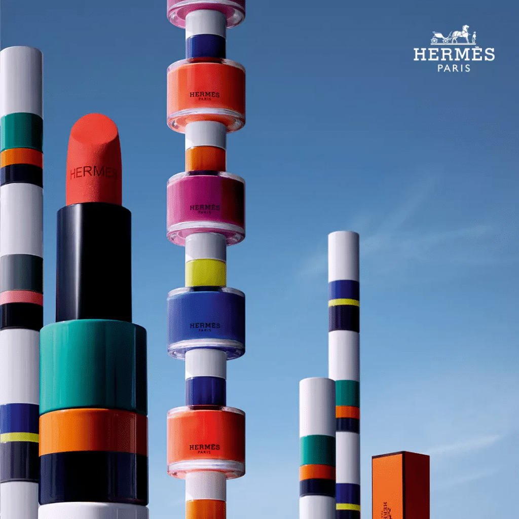 Các thỏi son và sơn móng tay Hermès được xếp chồng cao trên nền trời xanh
