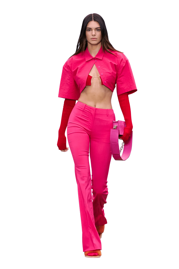 Người mẫu diện bộ trang phục màu hồng sáng gồm áo croptop và quần ống loe trên sàn diễn thời trang