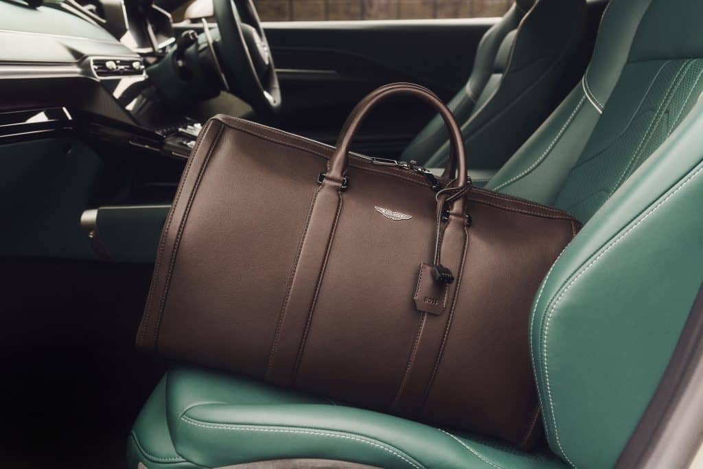 Túi da màu nâu nằm trên ghế xe Aston Martin bọc da xanh lục bảo
