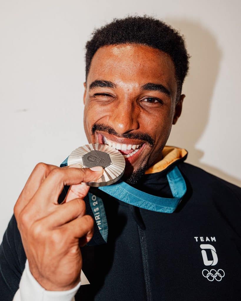 Vận động viên nam tươi cười nhìn vào huy chương Thế vận hội Paris 2024 vừa giành được