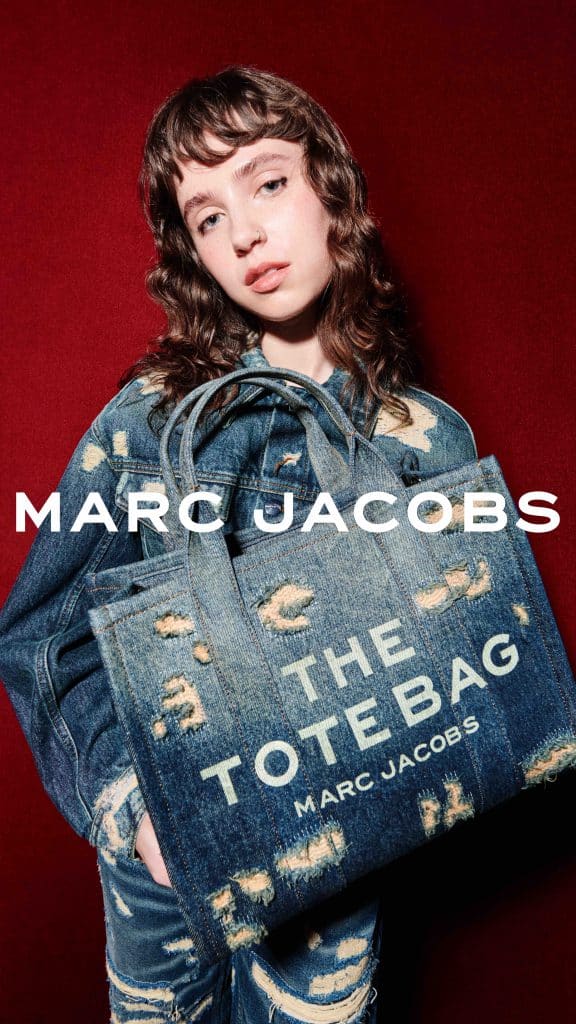 Cô gái trẻ diện trang phục denim và cầm túi xách The Tote Bag của Marc Jacobs