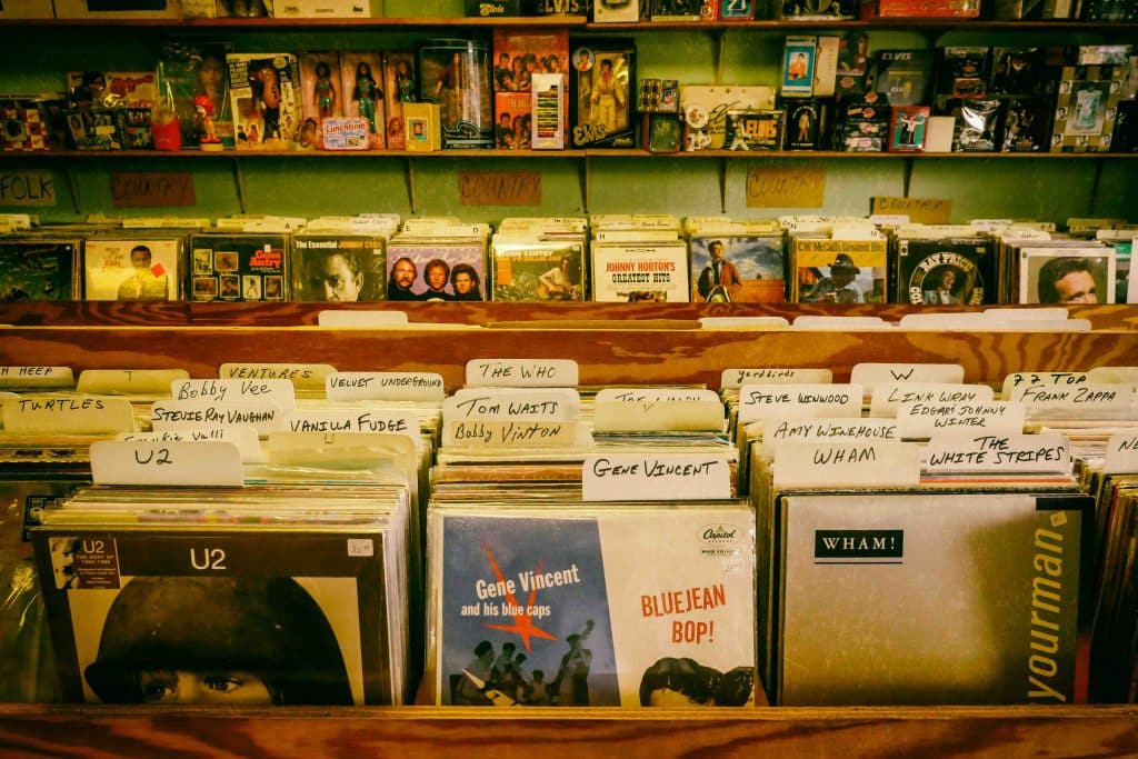 Các đĩa nhạc vinyl được sắp xếp trên kệ gỗ trong một cửa hàng âm nhạc