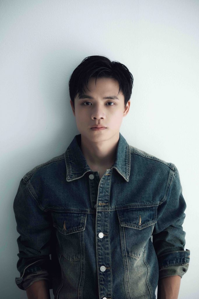 Chân dung người đàn ông trẻ mặc áo khoác denim nhìn thẳng vào ống kính