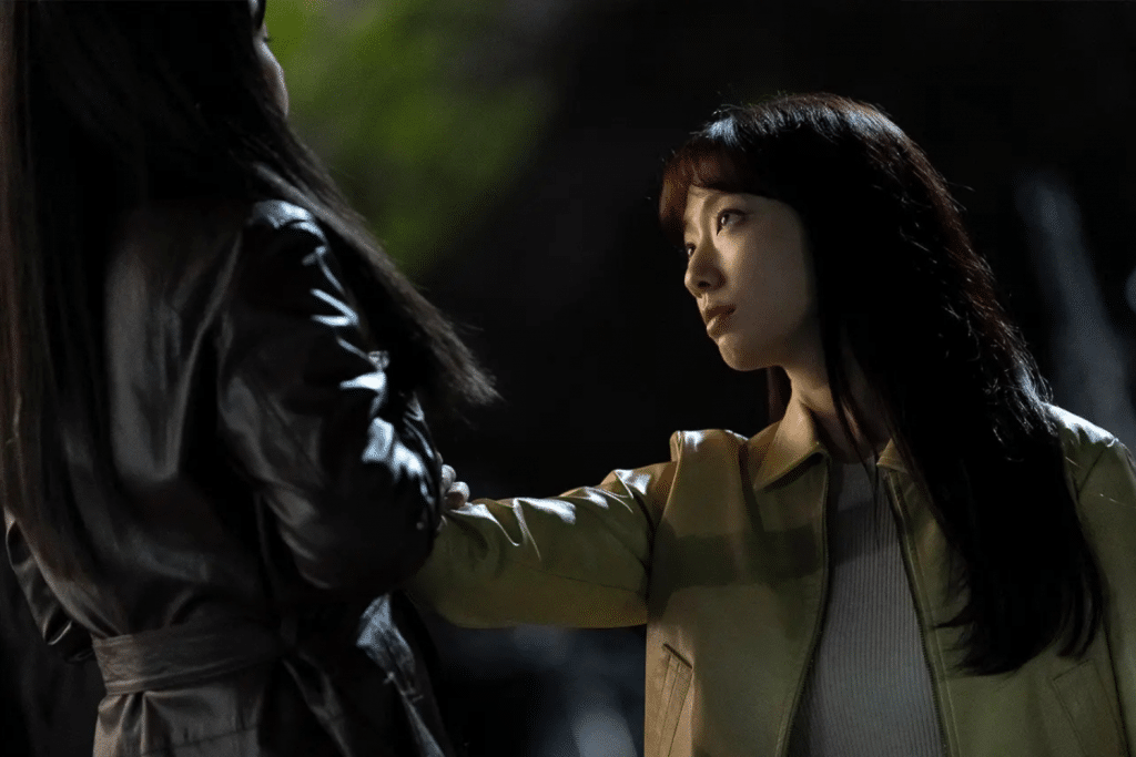 Một người phụ nữ nhìn lên đối diện với một người đàn ông mặc áo khoác đen