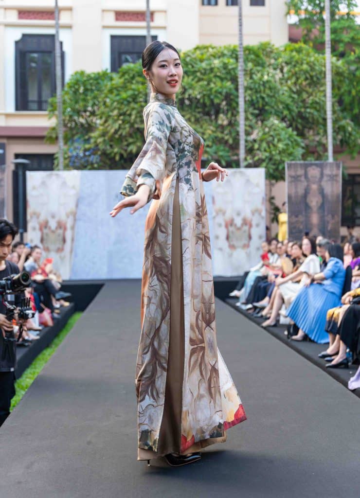 Người mẫu trình diễn áo dài lụa họa tiết hoa lá trên sàn catwalk