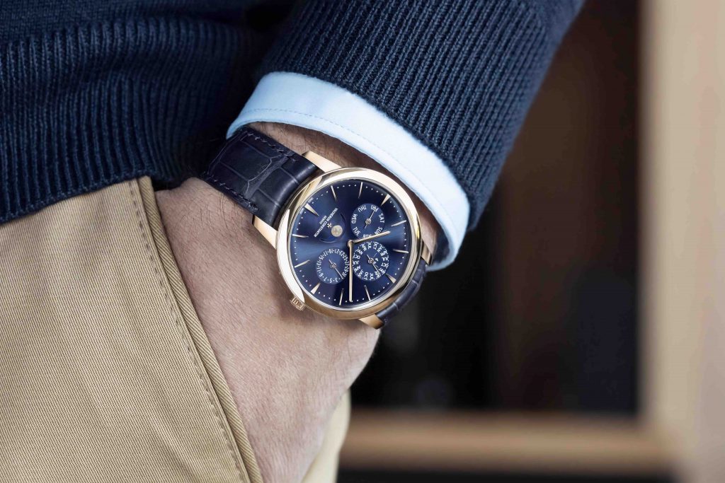 Người đàn ông đeo đồng hồ vàng mặt xanh dương với dây da cá sấu