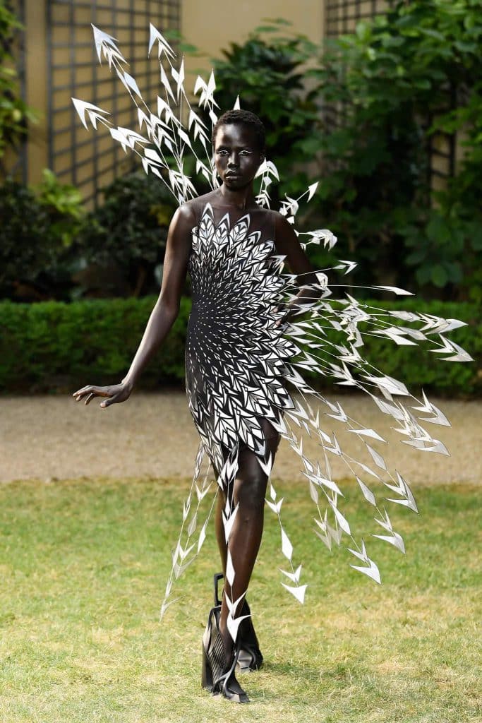 A model wears a striking black and silver couture dress with arrow like extensions