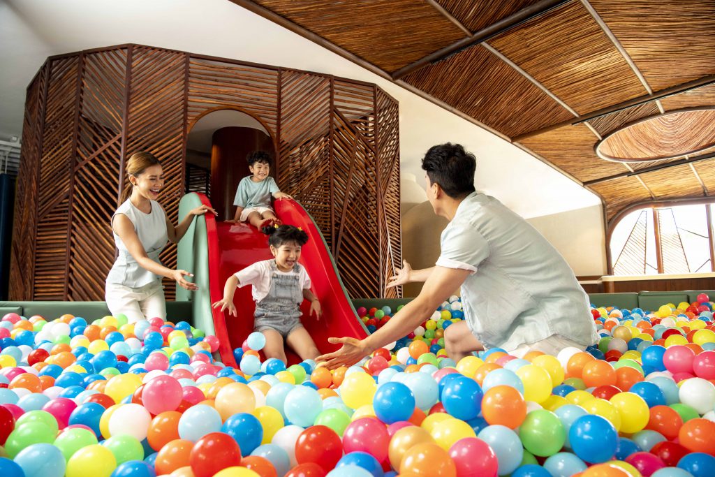 Families enjoy a colorful ball pit and slide at PLAY Kids Club