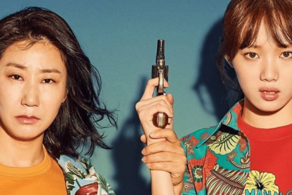 Hai cô gái trẻ nhìn thẳng với biểu cảm hài hước cùng một khẩu súng đồ chơi