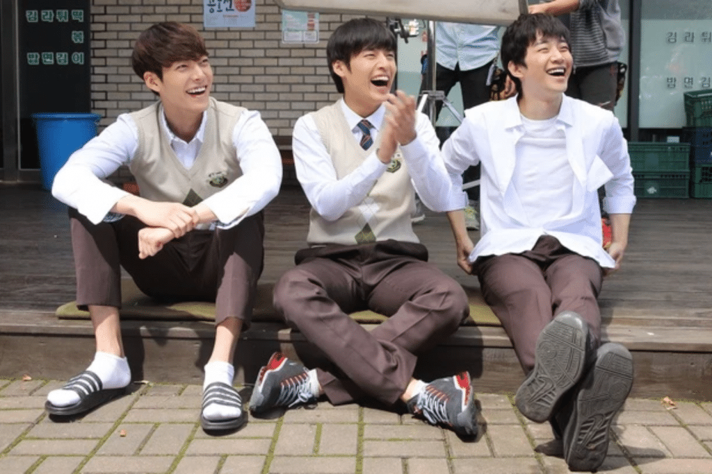 Ba nam sinh Hàn Quốc mặc đồng phục cười tươi rói bên ngoài cửa hàng