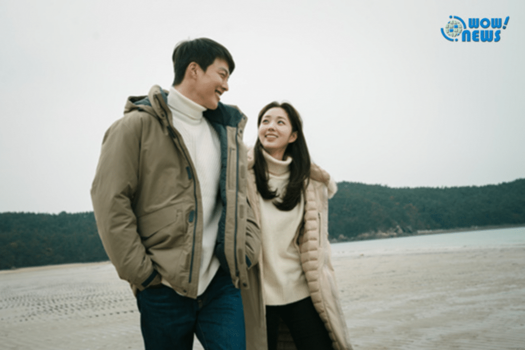 Cặp đôi trẻ hạnh phúc cùng nhau đi dạo trên bãi biển vào một ngày đông