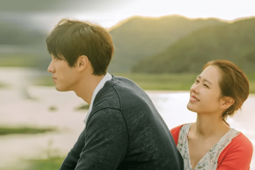 Cặp đôi trẻ nhìn nhau mỉm cười lãng mạn trong khung cảnh thiên nhiên tươi đẹp