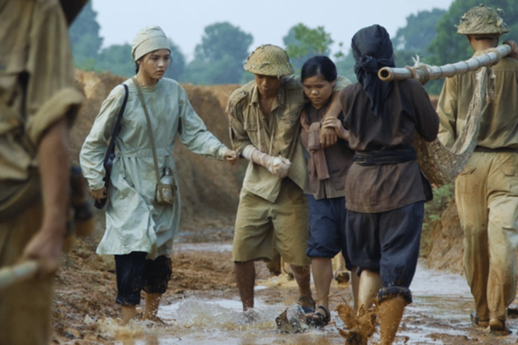 Những người dân giúp đỡ thương binh trong ngày mưa trên con đường đất