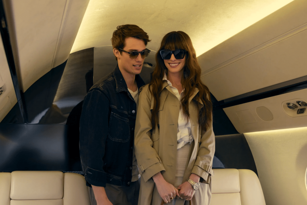 Cặp đôi trẻ trung mặc kính râm tươi tắn đang ngồi trên máy bay riêng